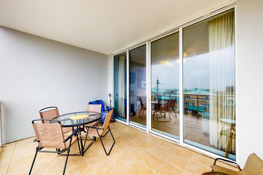 a dining room with a table and chairs on a balcony at Destin West Gulfside Villa V402 in Fort Walton Beach