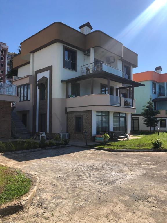 a large white house with a lot of windows at Seyran Seaside Apartments- 2-garden floor in Trabzon