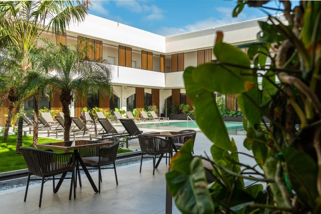 un resort con sedie e tavoli e una piscina di Limen Wellness Hotel & Spa a Campofelice di Roccella