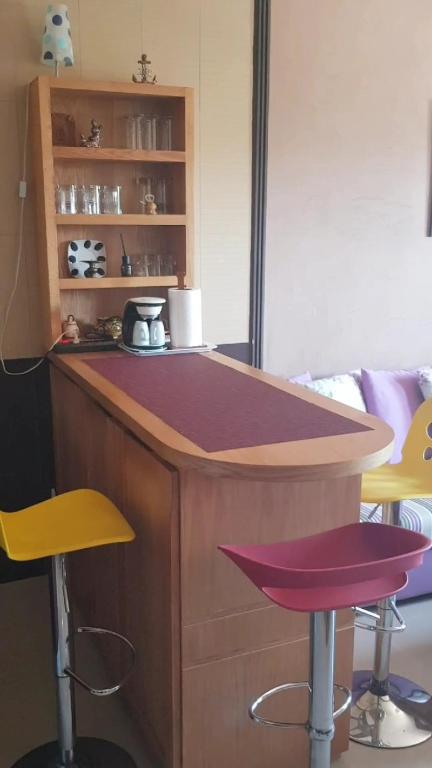 une cuisine avec un comptoir et deux tabourets dans l'établissement Studio meublé, à Riffiene