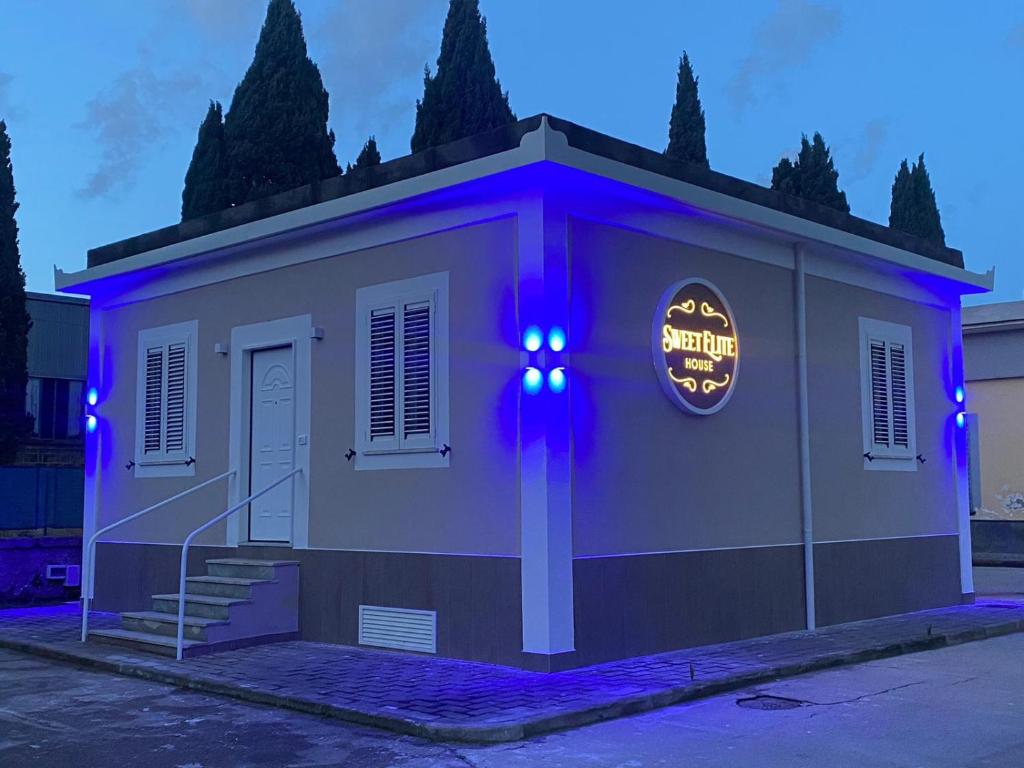ein Gebäude mit einem Schild mit lila Leuchten in der Unterkunft Sweet Elite House in Scafati