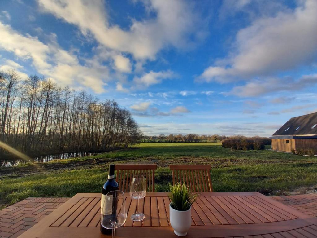 a wooden table with a bottle of wine and glasses at Ferienwohnung Landblick in Steenfeld