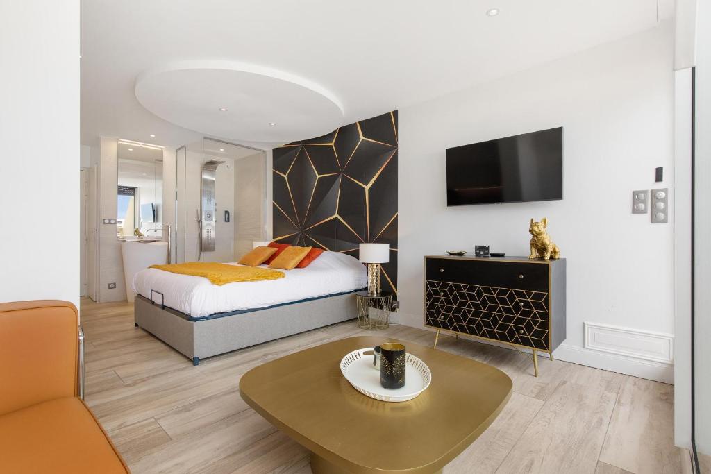 une chambre avec un lit, une table et une télévision dans l'établissement Village Naturiste R4N - Le Borrely Héliopolis, au Cap d'Agde