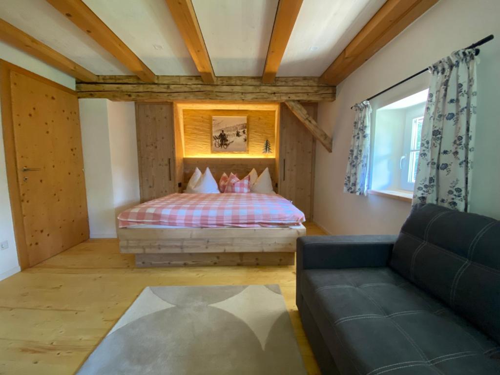 1 dormitorio con 1 cama y 1 sofá en una habitación en Plaik-Häusl, en Annaberg im Lammertal