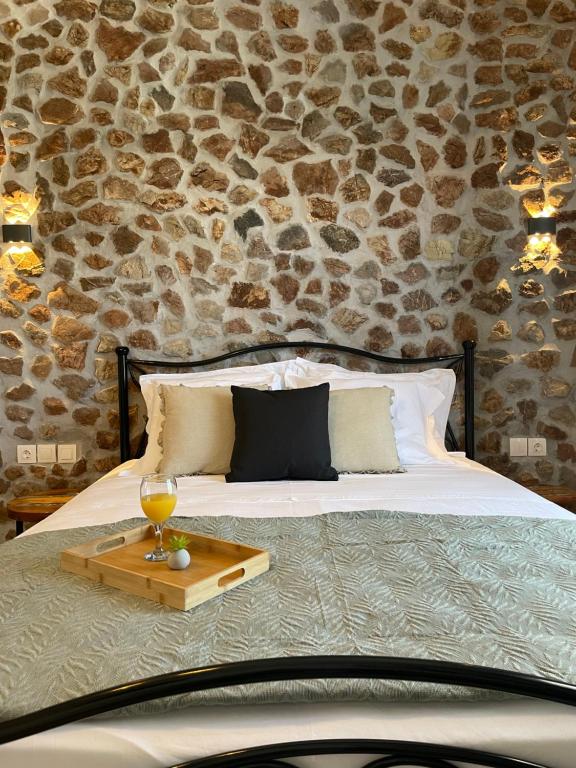 a bed with a tray with a glass of wine on it at Althea Apartments in Kolymbia