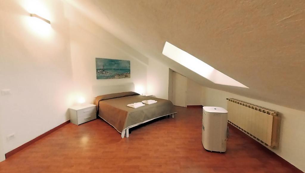 ein Schlafzimmer mit einem Bett im Dachgeschoss in der Unterkunft VIOLA - A Due Passi Dal Mare in Savona