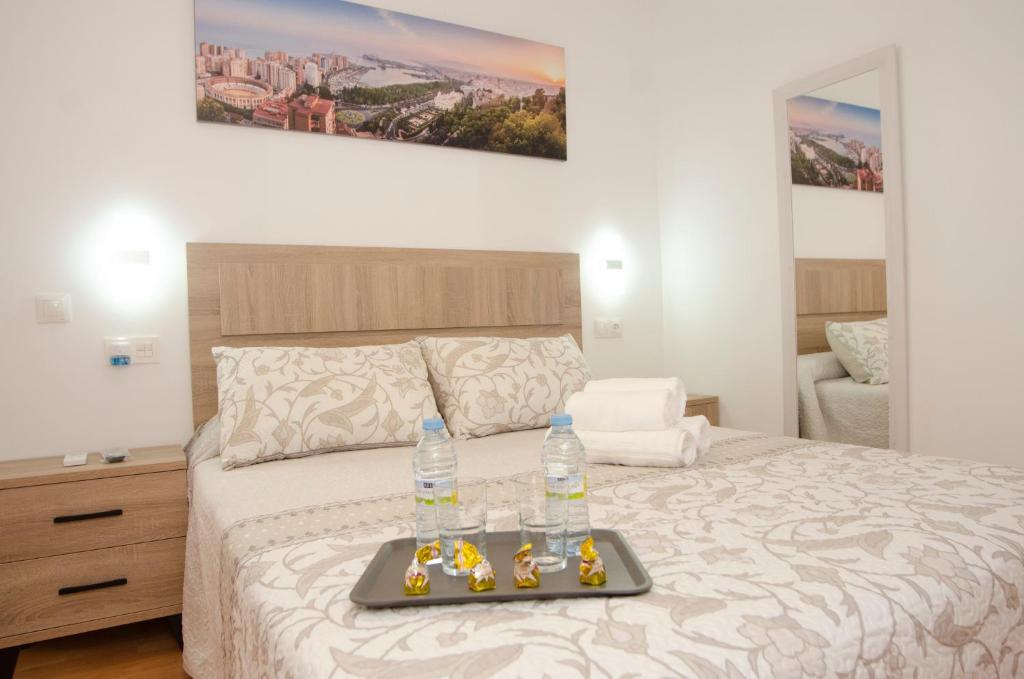 - un lit avec un plateau/bouilloire et 2 bouteilles d'eau dans l'établissement Alojamiento Alameda, à Malaga