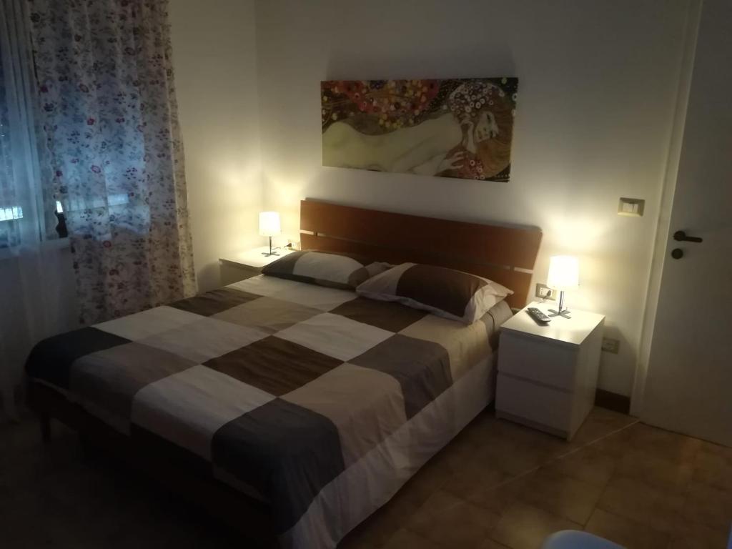 ein Schlafzimmer mit einem großen Bett und zwei Nachttischen in der Unterkunft Affittacamere Stazione 24 in Cervignano del Friuli