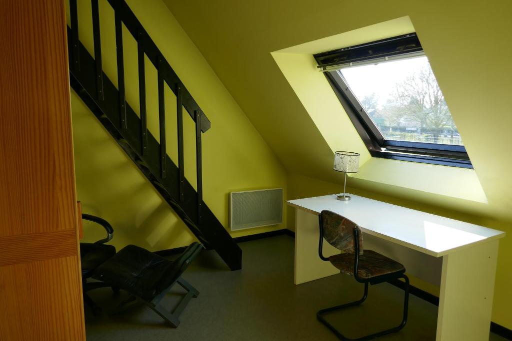 une pièce avec un bureau, une fenêtre et un escalier dans l'établissement Chambre meublée en duplex indépendante, à Caen
