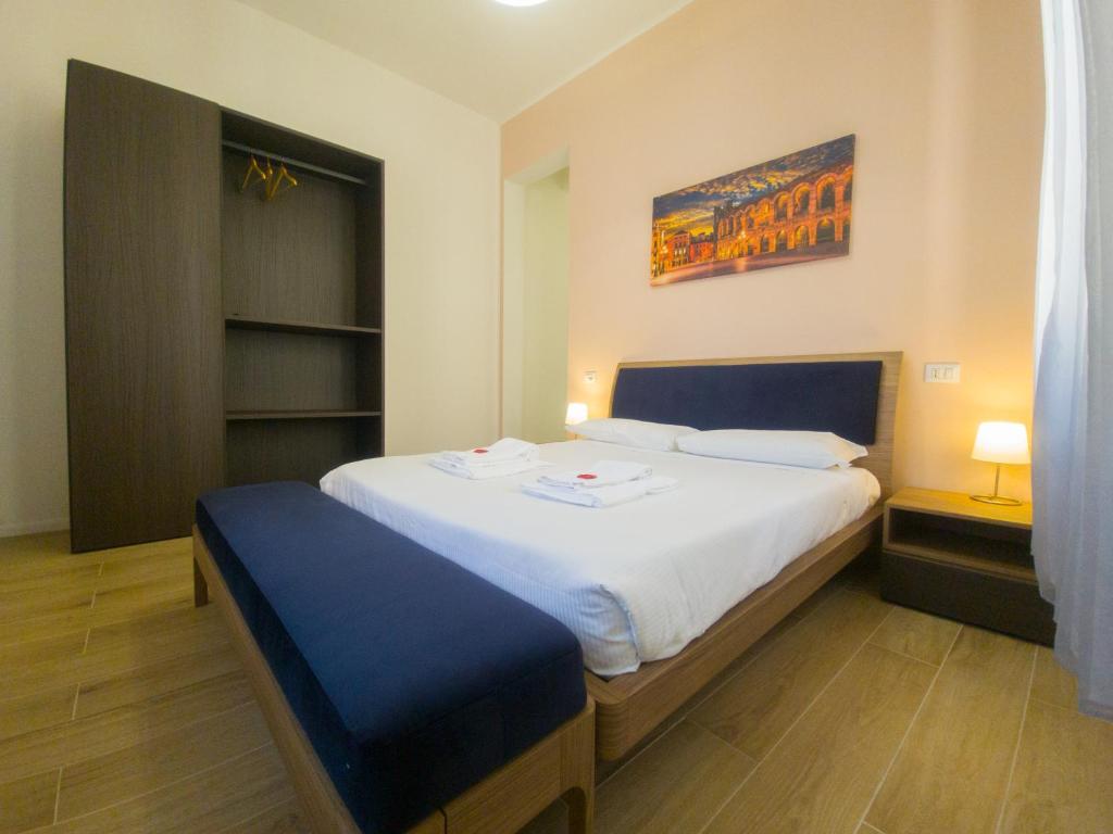 sypialnia z dużym łóżkiem z niebieskim zagłówkiem w obiekcie Italianflat - Rentroom Verona w Weronie