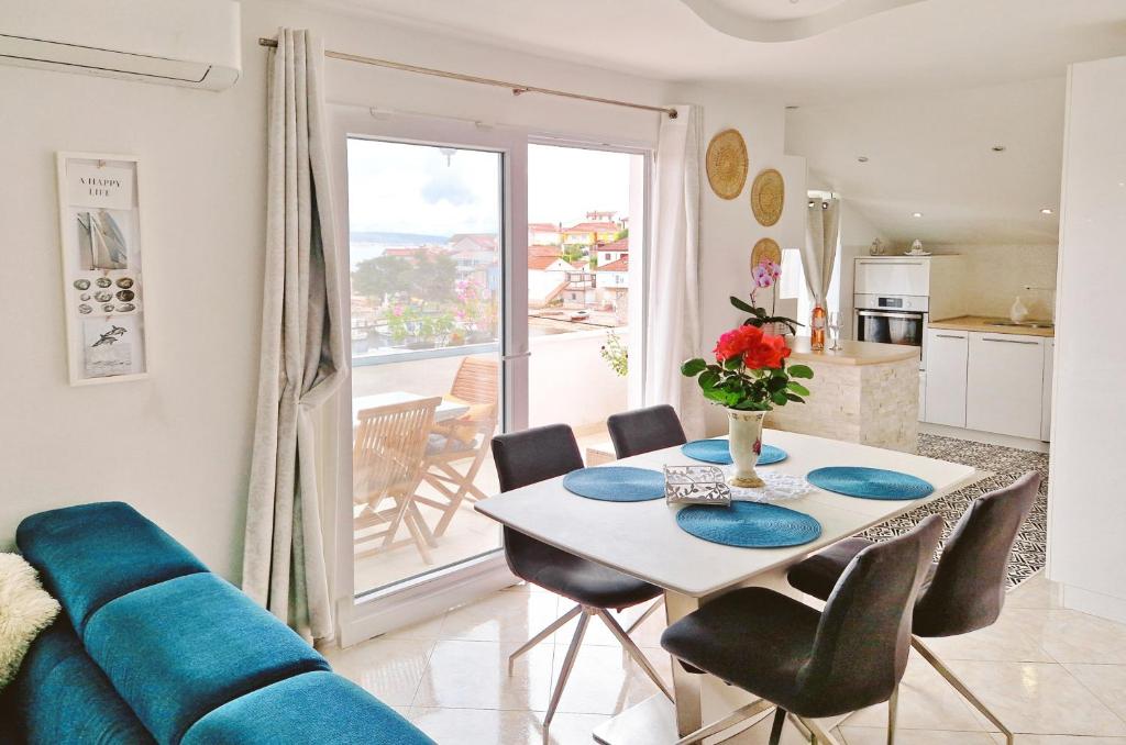 uma sala de estar com uma mesa e um sofá azul em Apartment Sea view em Kali