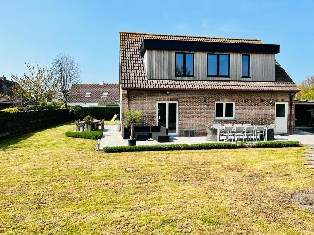 una casa de ladrillo con césped delante en Maison - Le Sable Doux, en Middelkerke