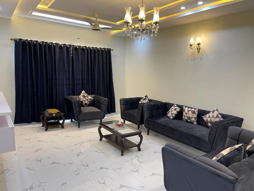 a living room with couches and a chandelier at Bahria Residency 1 in Islamabad