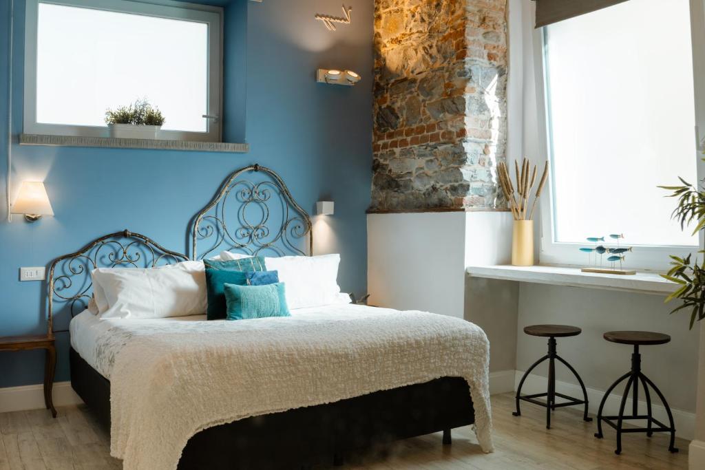 拉斯佩齊亞的住宿－樂5漁村拉斯佩齊亞旅館，一间卧室配有一张带蓝色墙壁和水槽的床