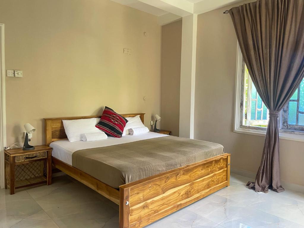 a bedroom with a large bed and a window at Habibi Hostel & Restaurant in Unawatuna