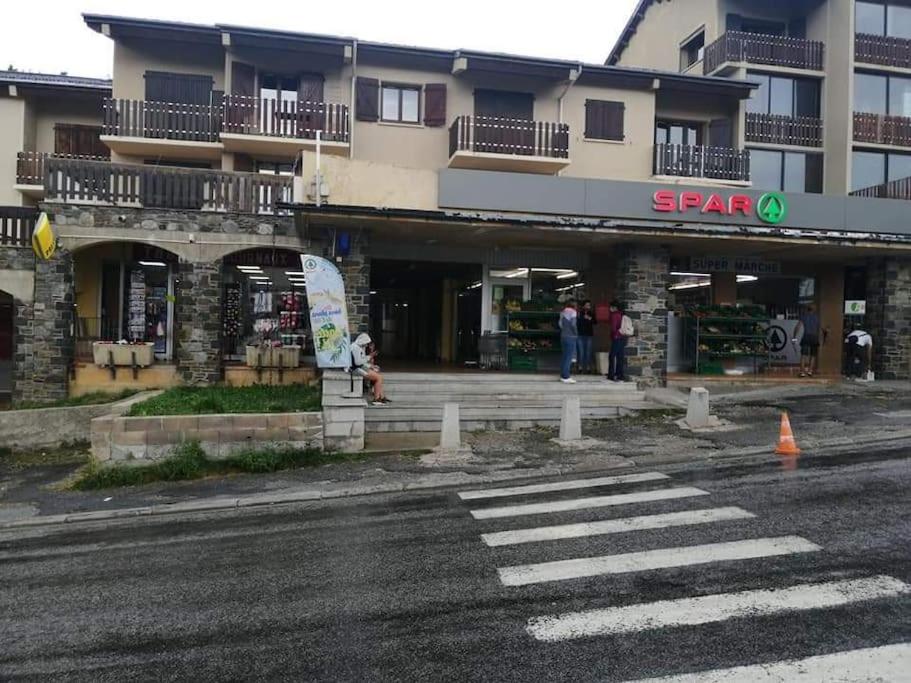un magasin devant un bâtiment avec des personnes debout à l'extérieur dans l'établissement Studio 4 personnes, aux Angles