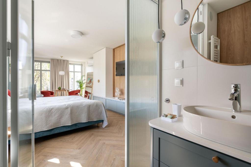 łazienka i sypialnia z łóżkiem i umywalką w obiekcie Baltic Wave Boutique Apartments with sauna and gym w mieście Sopot
