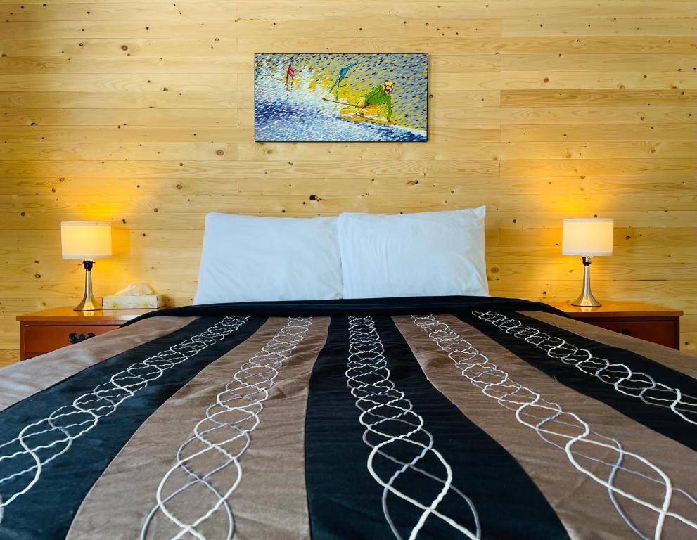 - une chambre avec un lit avec deux lampes et un tableau mural dans l'établissement Attitude Montagne, à Saint-Adolphe-d'Howard