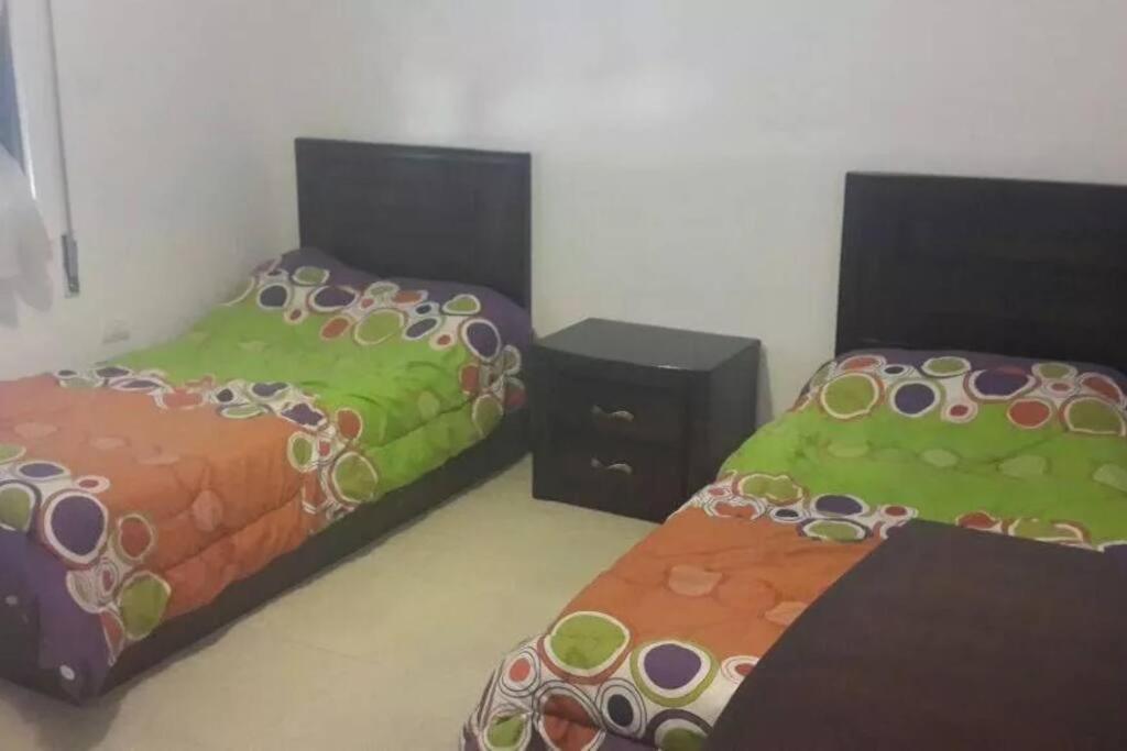 a room with two beds with green and orange at شقه مفروشه سوبر ديلوكس in Amman