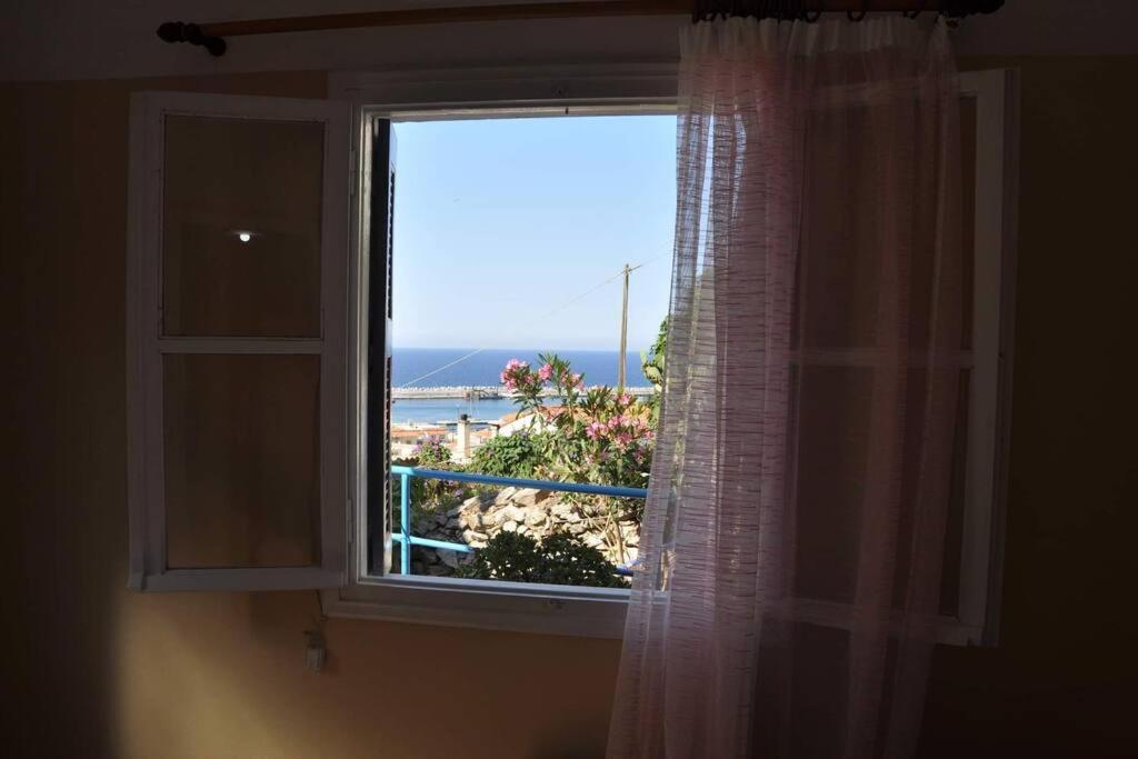 a window with a view of the beach at Evdilos apartments with a view in Evdilos
