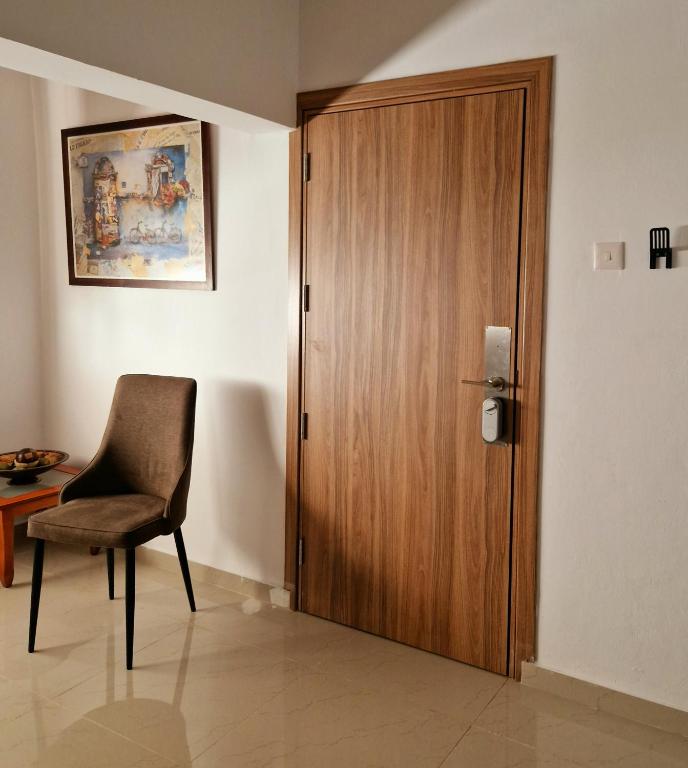 a wooden door in a room with a chair and a table at Palm Sea Suite 17 in Larnaca