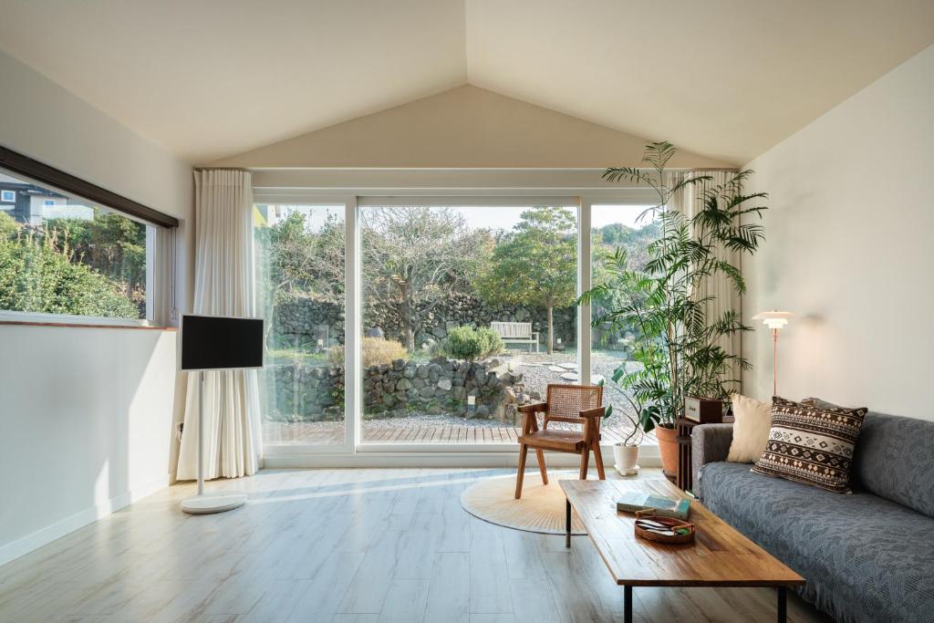 a living room with a couch and a table at Day One Jeju Sulrem in Jeju