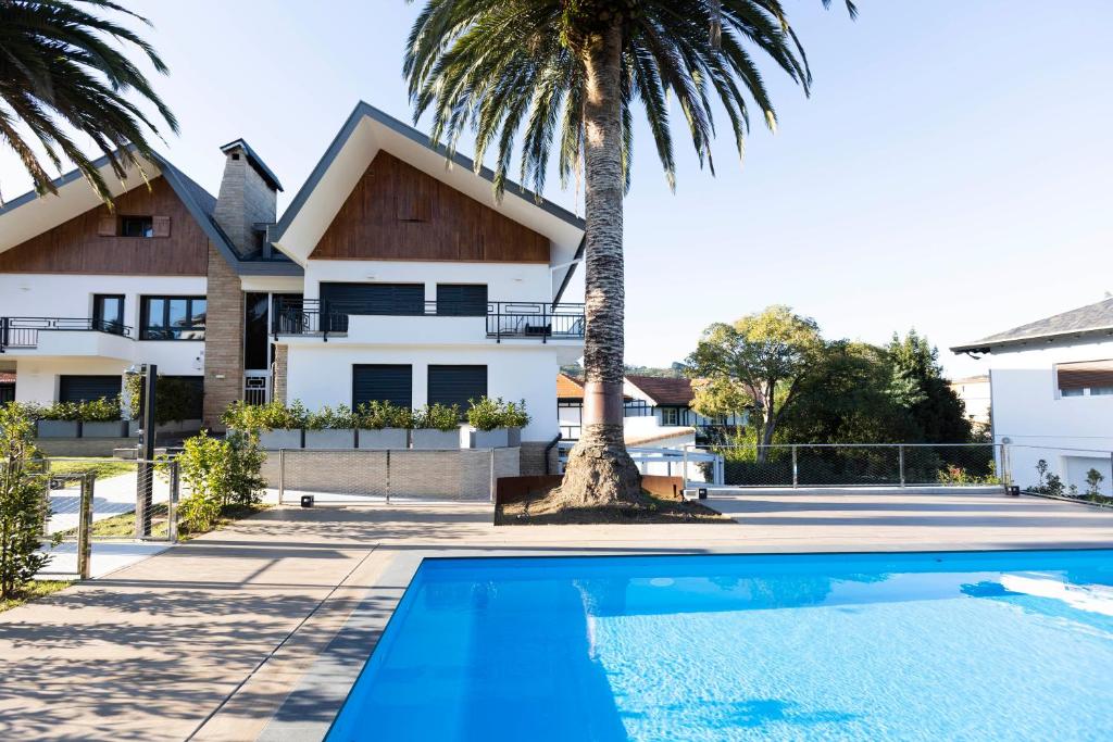 uma villa com uma palmeira e uma piscina em Akartegi by Basquelidays em Hondarribia