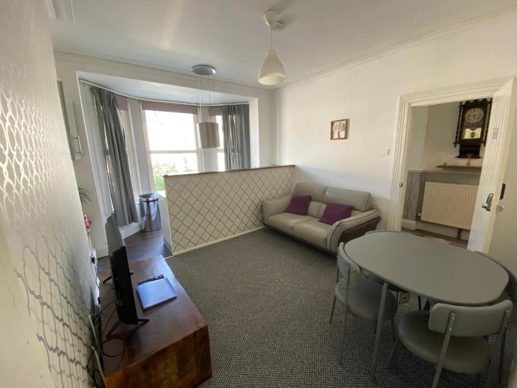 ein Wohnzimmer mit einem Sofa und einem Tisch in der Unterkunft The Walnut Suite lovely one bedroom flat in Stoke. in Plymouth