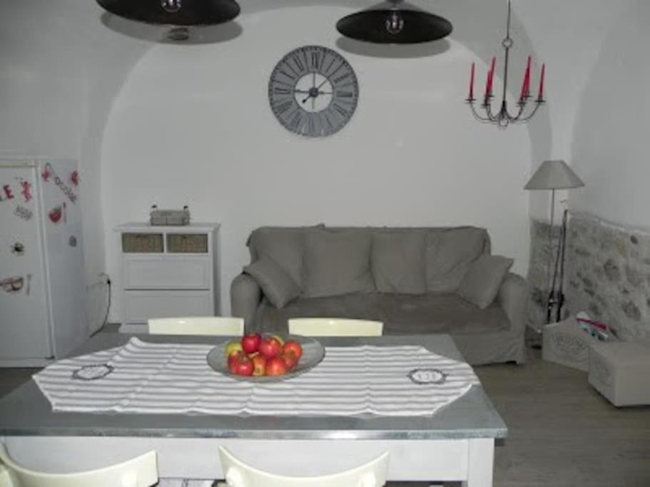 een woonkamer met een tafel met een fruitschaal erop bij Charmant gîte 2 étoiles, parking privé à Ruoms in Ruoms