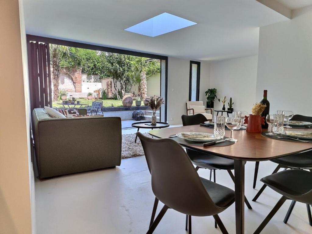 une salle à manger avec une table et des chaises dans l'établissement Le Jardin Secret - Piscine - Clim - Haut de gamme, à Albi