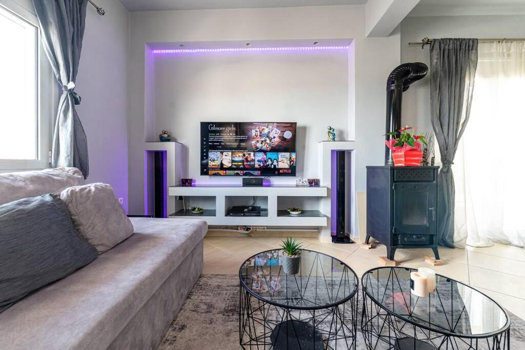 uma sala de estar com um sofá e uma televisão em MegaLuxe Apartment em Iráclio