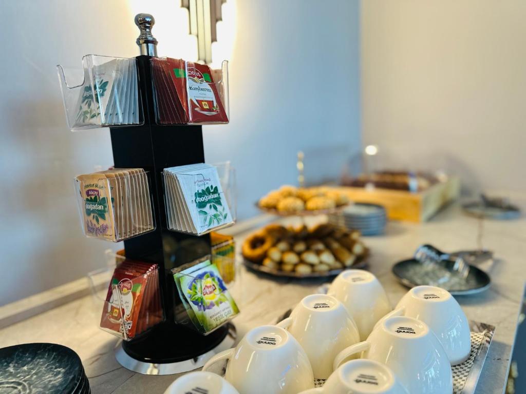 a table topped with white cups and plates of food at Skymoon Istanbul Airport Hotel in Arnavutköy
