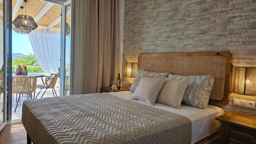 a bedroom with a large bed with a brick wall at Plaka Philoxenia Apartments in Plaka Milou