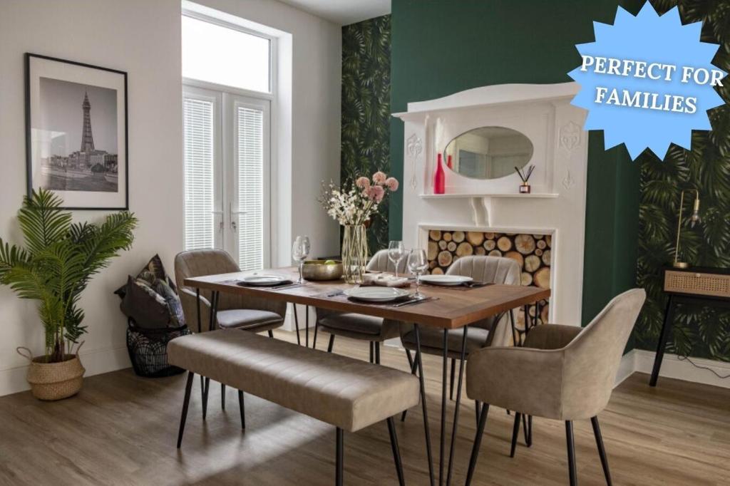 The Callie by Sasco Apartments في بلاكبول: غرفة طعام مع طاولة وكراسي وجدار أخضر