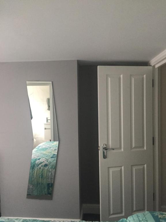 a bedroom with a door and a mirror at home away from home in Croydon