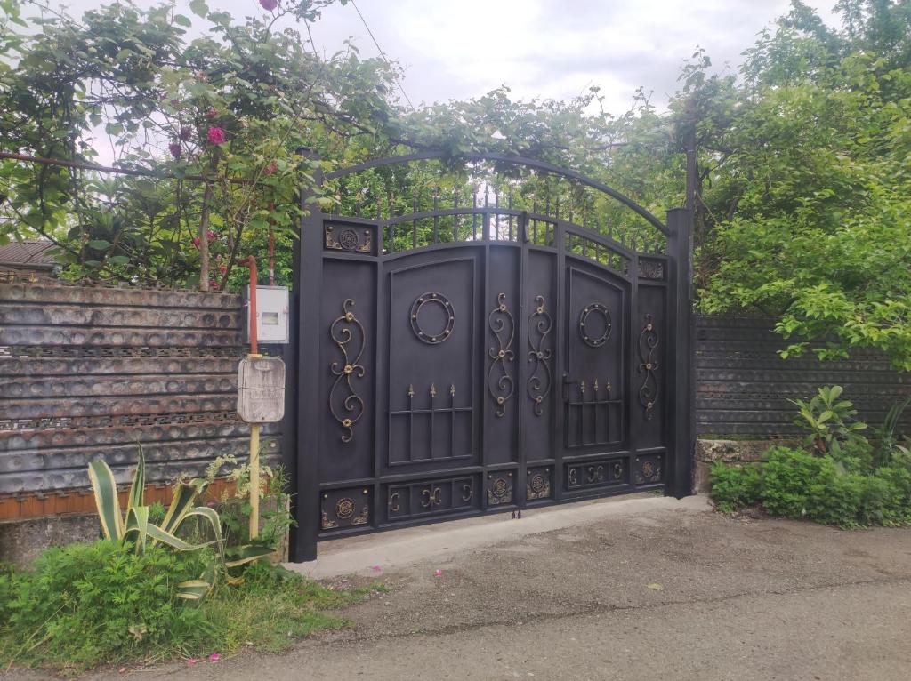 a black gate in a yard with a fence at Private House in Batumi in Batumi