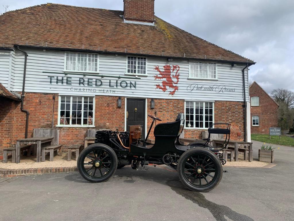 an old car parked in front of a building at The Red Lion Charing Heath in Charing