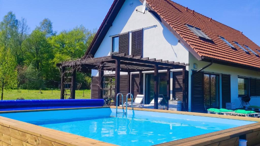 una casa con piscina frente a una casa en Siedlisko Gregorowo, en Ustka