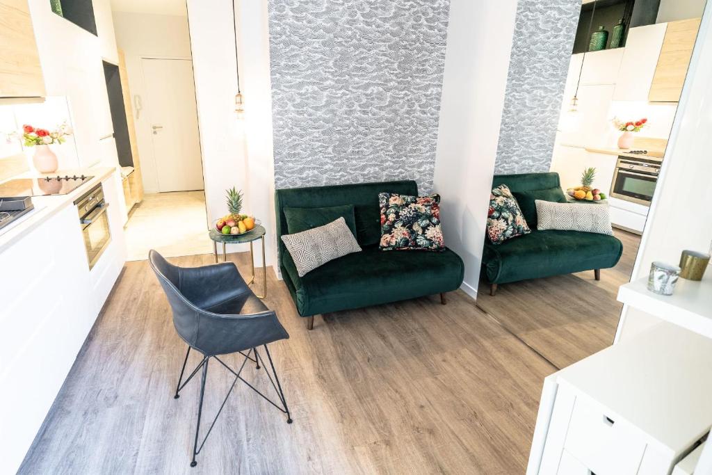 ein Wohnzimmer mit 2 grünen Stühlen und einem Tisch in der Unterkunft Appartement Bocuse -terrasse -Oullins-Lyon in Oullins