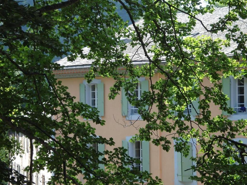Escouloubre的住宿－Notre-Dame d'Escouloubre，粉红色的建筑,拥有白色的窗户和树木