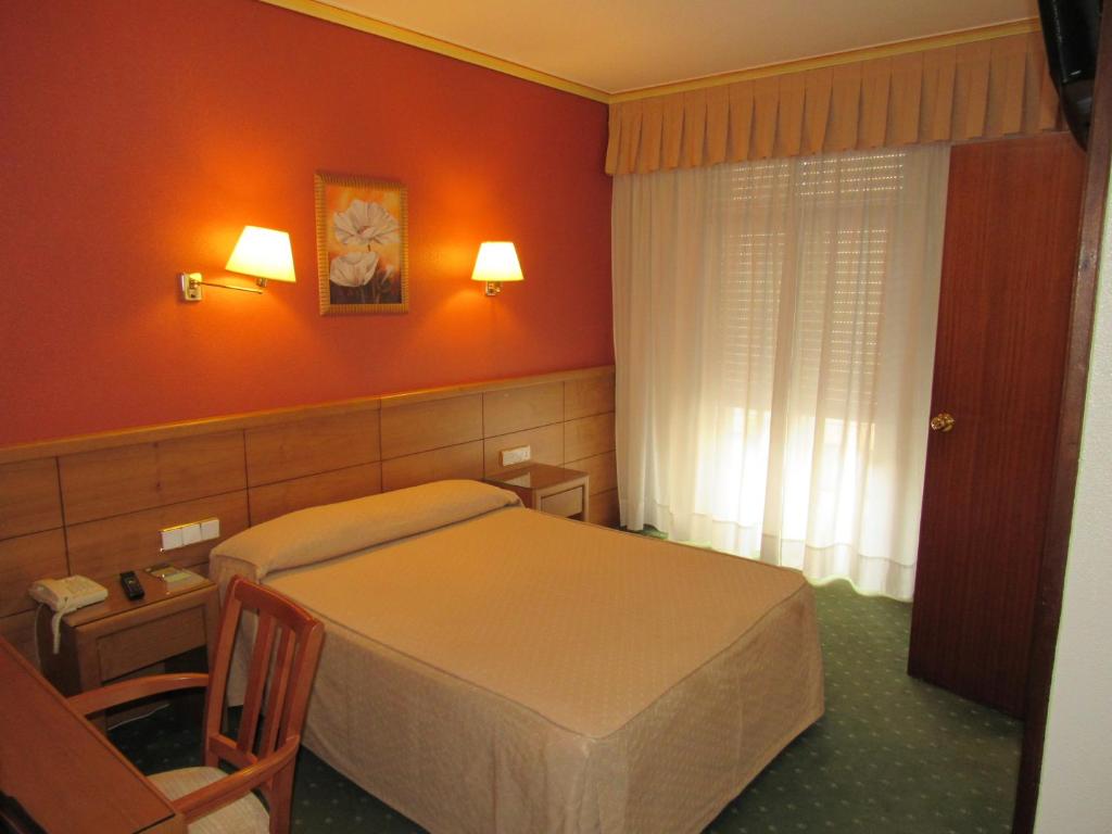a hotel room with a bed and a window at Hotel Virgen del Camino Pontevedra in Pontevedra