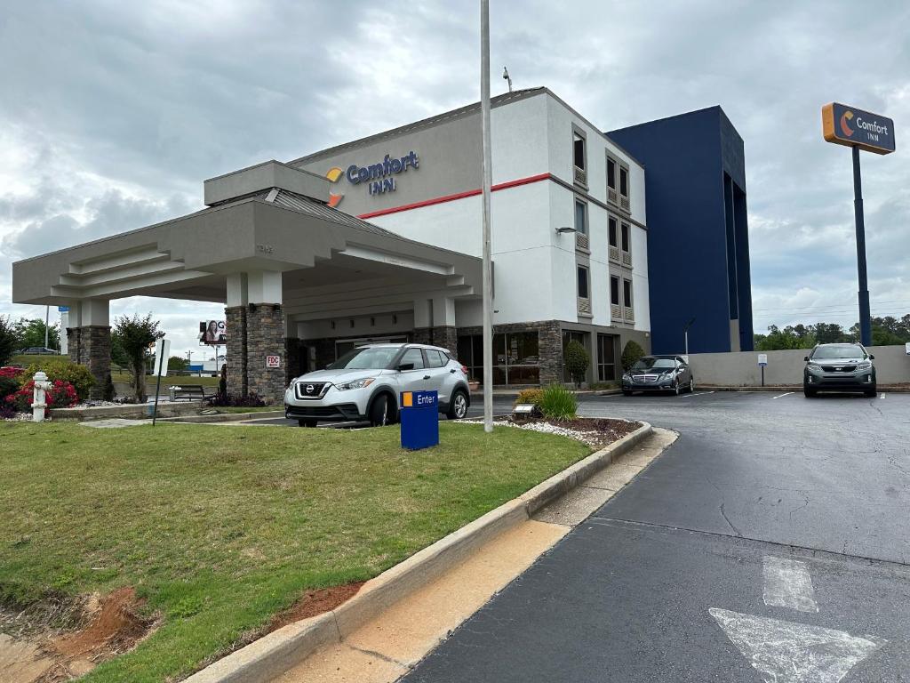 a car dealership with a car parked in a parking lot at Comfort Inn in Conyers