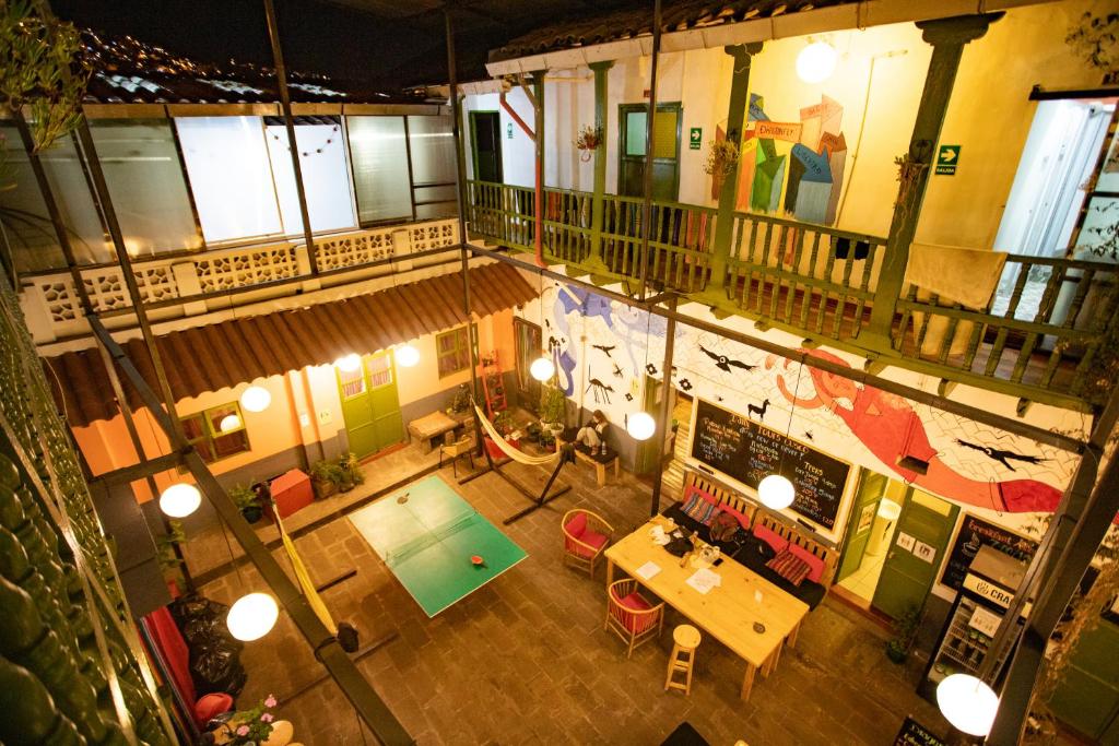 - une vue de tête sur un restaurant avec une table et une piscine dans l'établissement Dragonfly Hostels Cusco, à Cusco