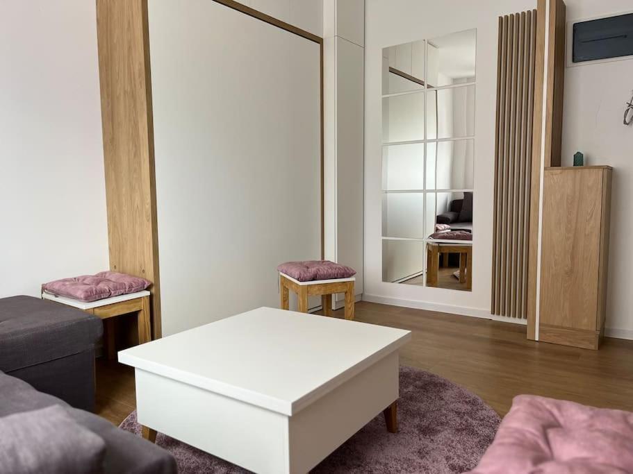 Sala de estar con mesa de centro blanca y espejo en Apartment Centar, en Podgorica