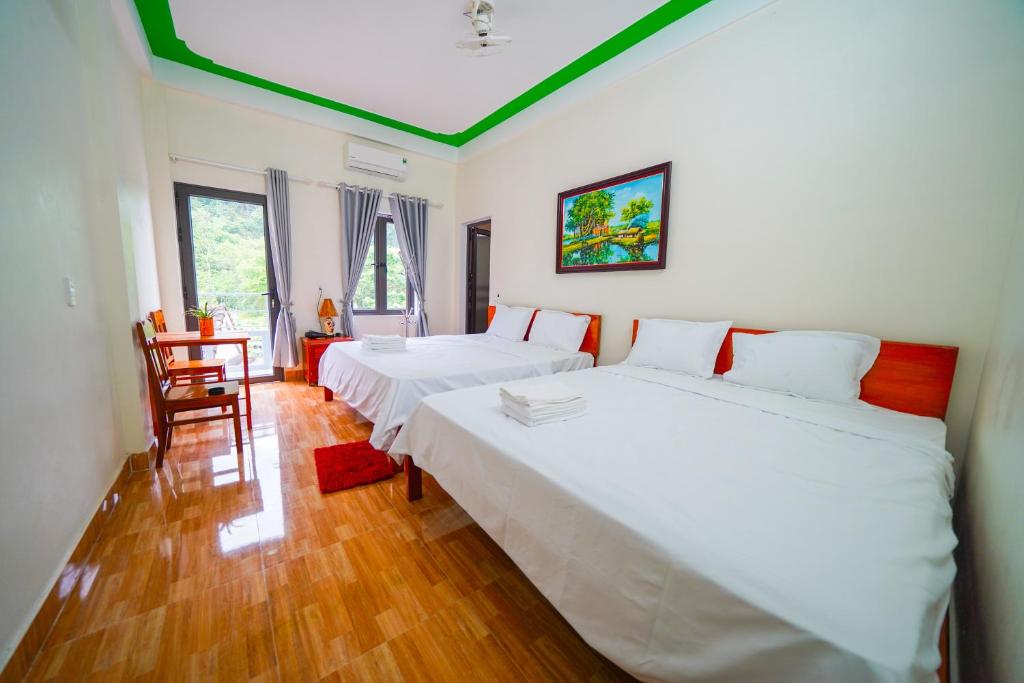 Un dormitorio con 2 camas y una silla. en Phong Nha Magic Fingers Homestay and Spa, en Phong Nha