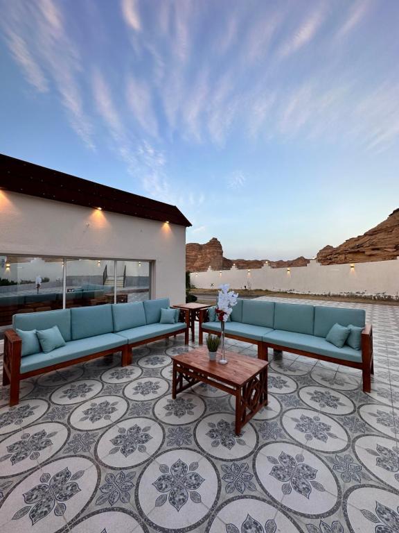 un soggiorno con divani blu e un tavolo di منتجع مرايا a Al Ula