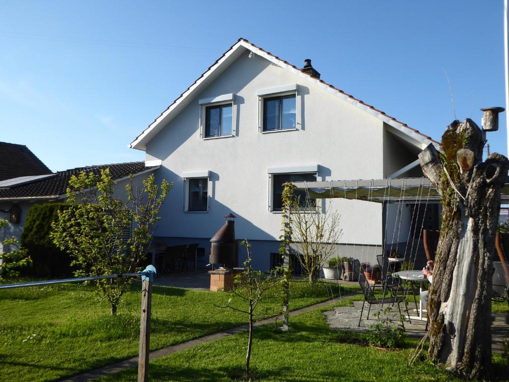 ein weißes Haus mit einem Garten davor in der Unterkunft 22 – Zimmer & Zmorge in Kreuzlingen