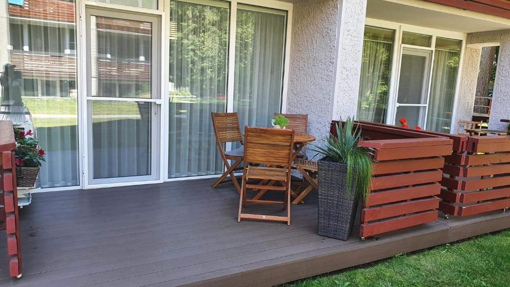 a porch with two chairs and a table on it at Smilties apartamentai in Juodkrantė