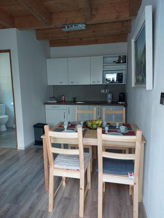 a kitchen with a table and two chairs and a kitchen with white cabinets at Gite de Moulin Maurt 1 in Xertigny