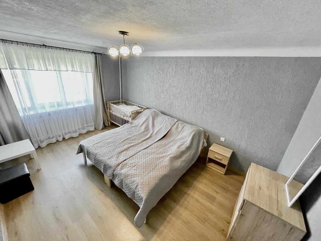a bedroom with a bed and a large window at SMILE in Ventspils